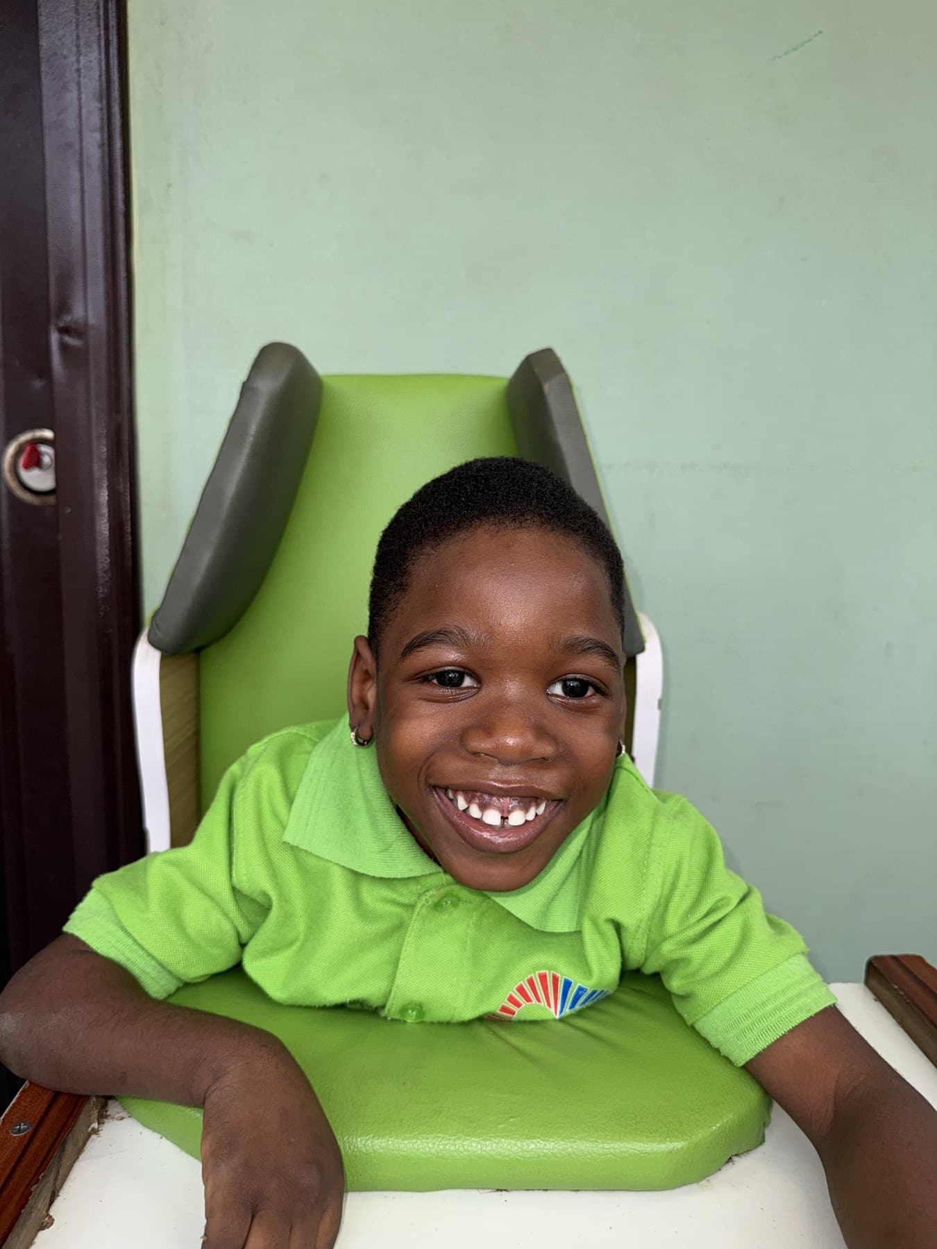A child in a supportive chair laughing during a session