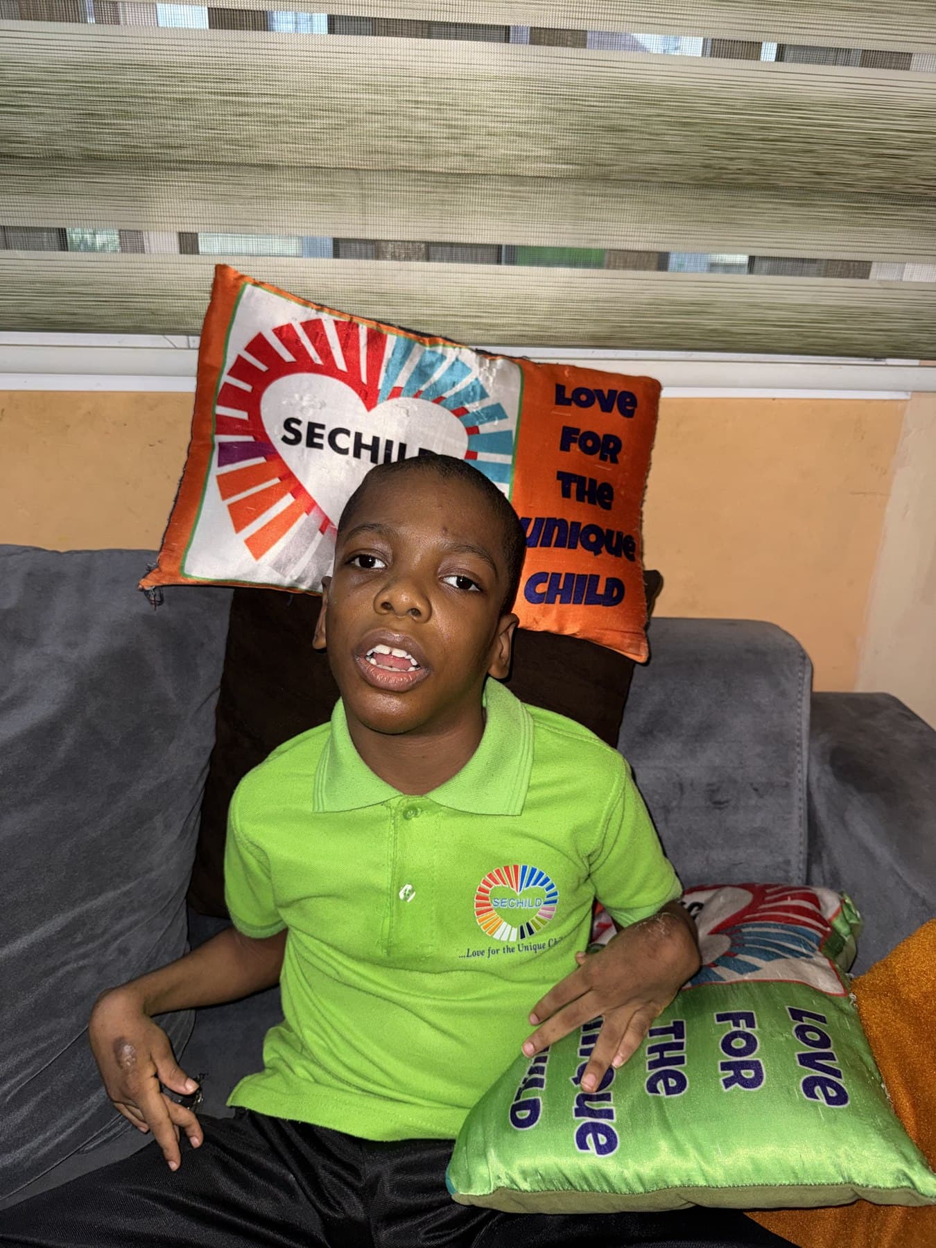 A child at home, resting comfortably against a SECHILD-branded cushion