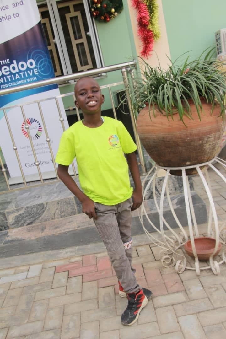 A child standing outside SECHILD's center, smiling